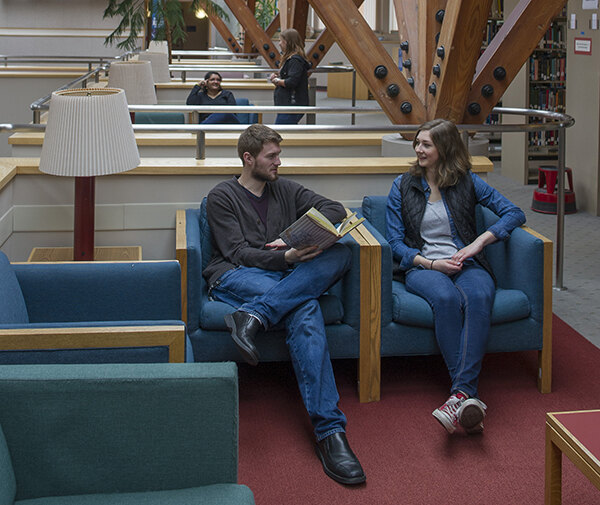 Two students talking in the library