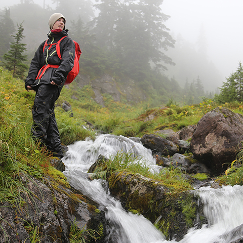 Hiker overlooking mountain stream