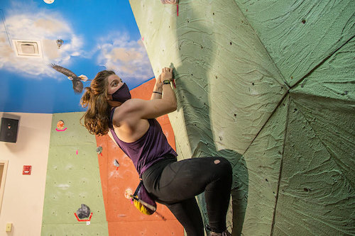 Woman climbing on the REC climbing wall