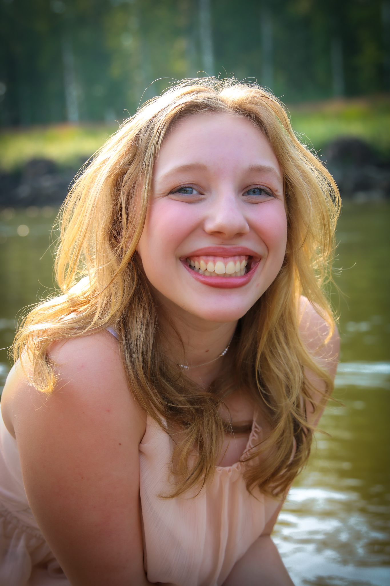 tutor Maddie Brehmer smiles by a lake